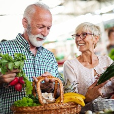 A happy older couple buying fresh foods